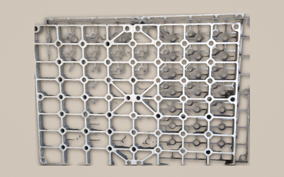 Cast heat-treatment base tray with a grid pattern